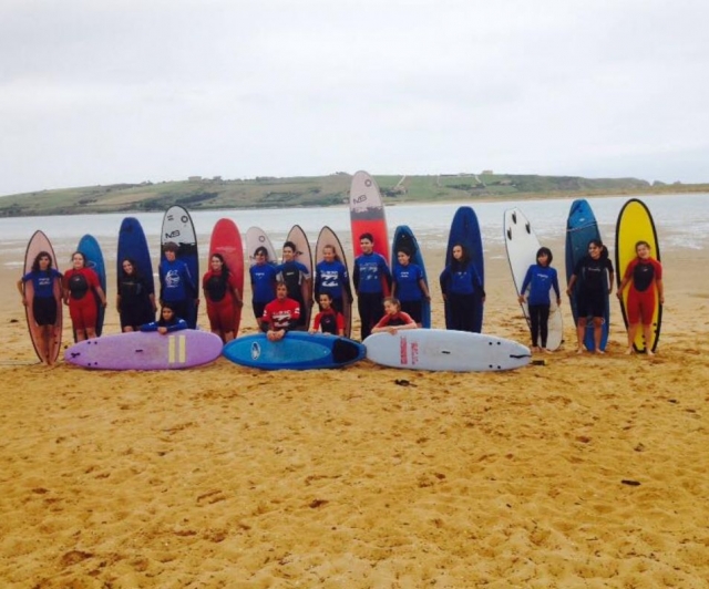  学生拿着冲浪板站立 